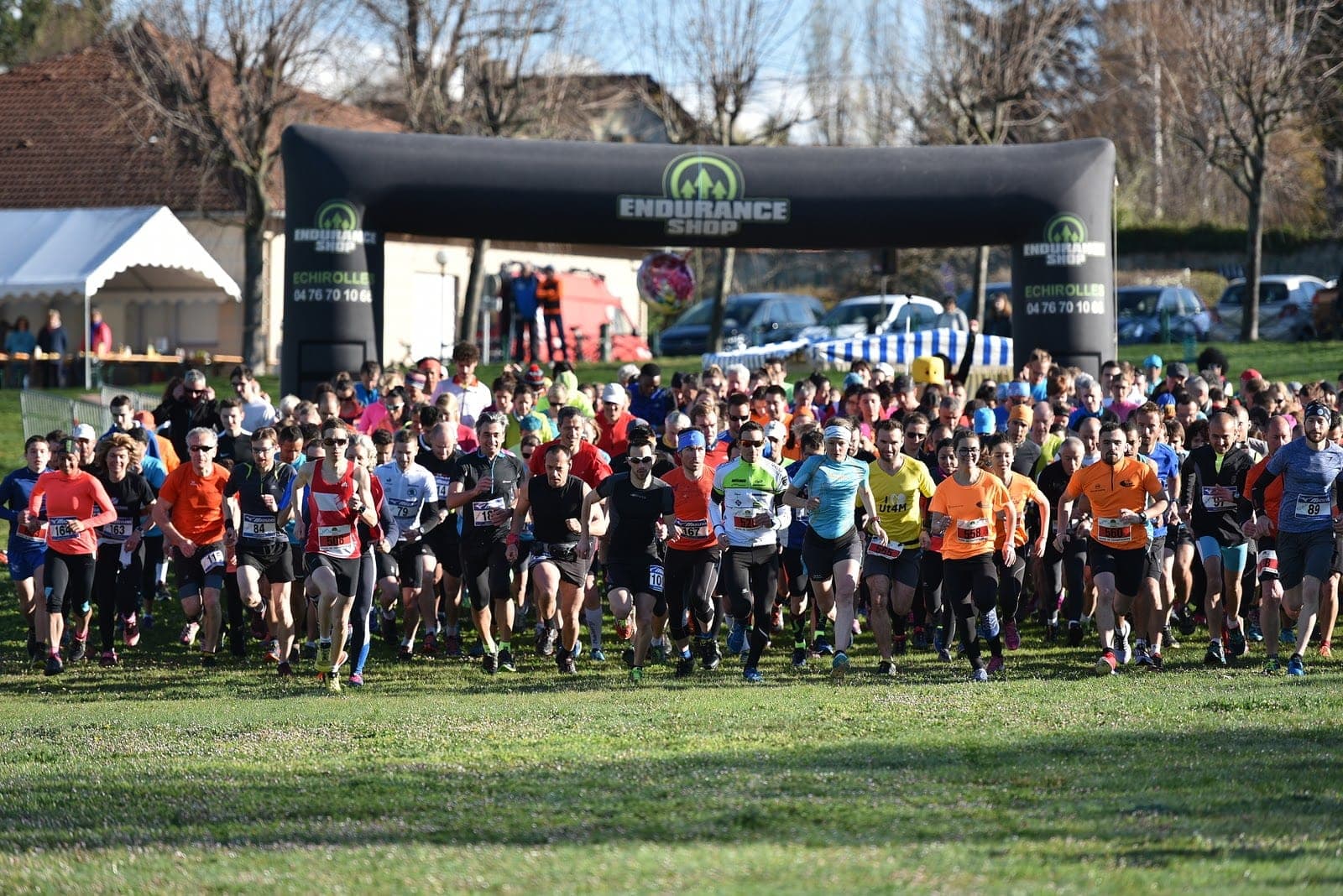 Départ du cross de Champagnier : la foule des coureurs s'élance sous l'arche